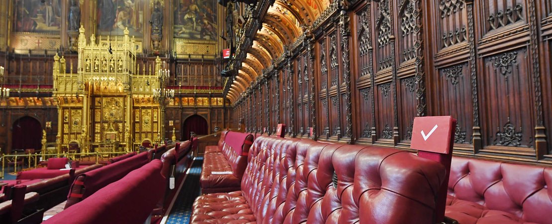 Red benches in the House of Lords, symbolising the seating arrangement for Lords during sessions.