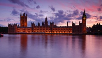 The Big Ben clock tower illuminated by the warm hues of sunset, creating a stunning silhouette against the evening sky.