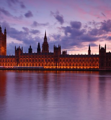 The Big Ben clock tower illuminated by the warm hues of sunset, creating a stunning silhouette against the evening sky.