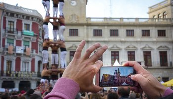 Hand held smartphone taking a picture of Castells Performance