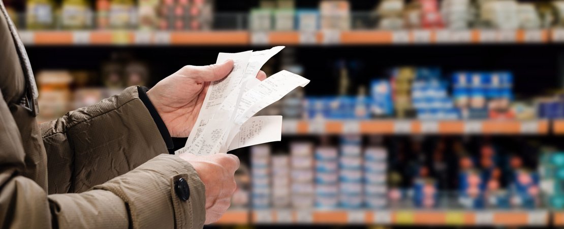 Minded man viewing receipts in supermarket and tracking prices. Image by Denys Kurbatov