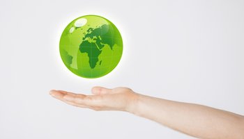 mans hand holding green globe