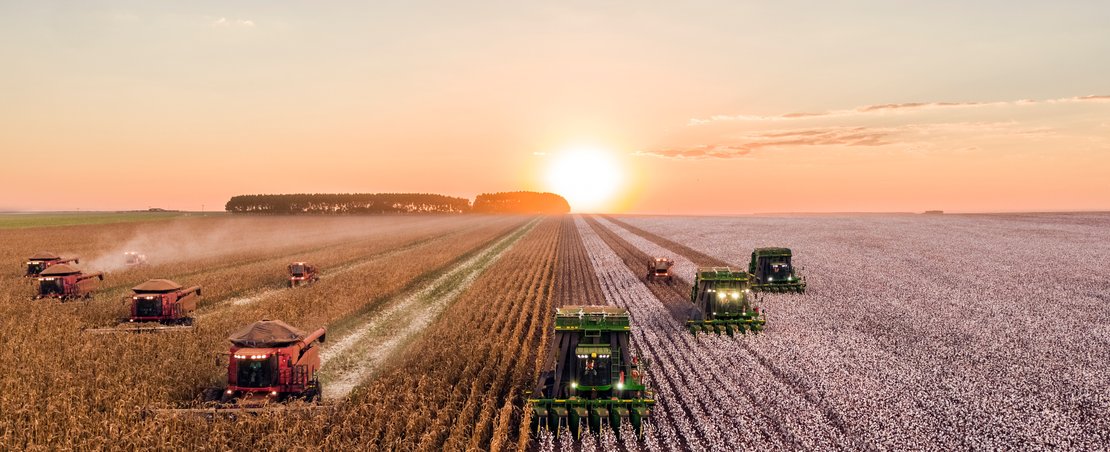 Tractors in field at sunset