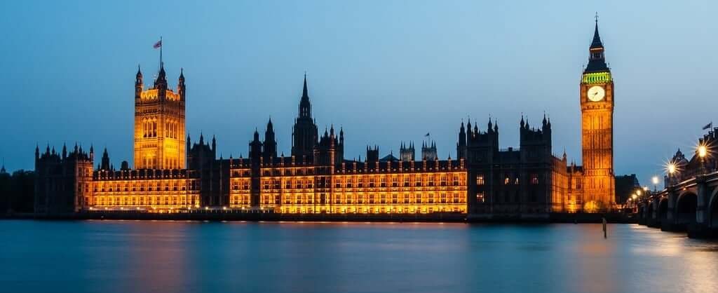 Night view of Big Ben clock tower and the Houses of Parliament, beautifully lit, highlighting their iconic structures and details.