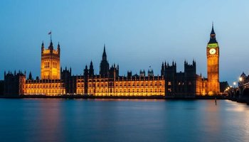 Night view of Big Ben clock tower and the Houses of Parliament, beautifully lit, highlighting their iconic structures and details.